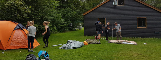Enkele kinderen en volwassenen zijn de tenten aan het opzetten