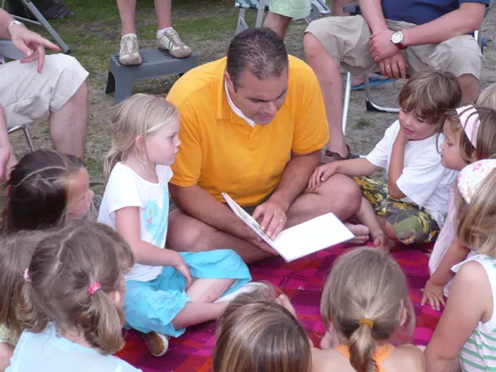 Een vader vertelt een verhaaltje aan zijn dochter en andere kinderen