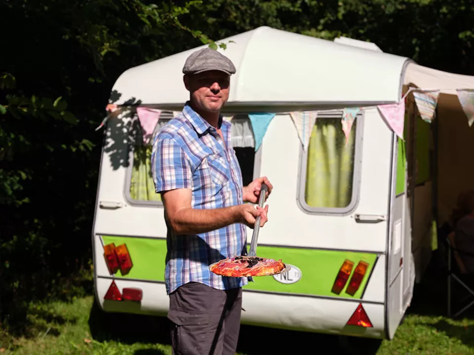 Een bezoeker is eten aan het klaarmaken op de groepscamping