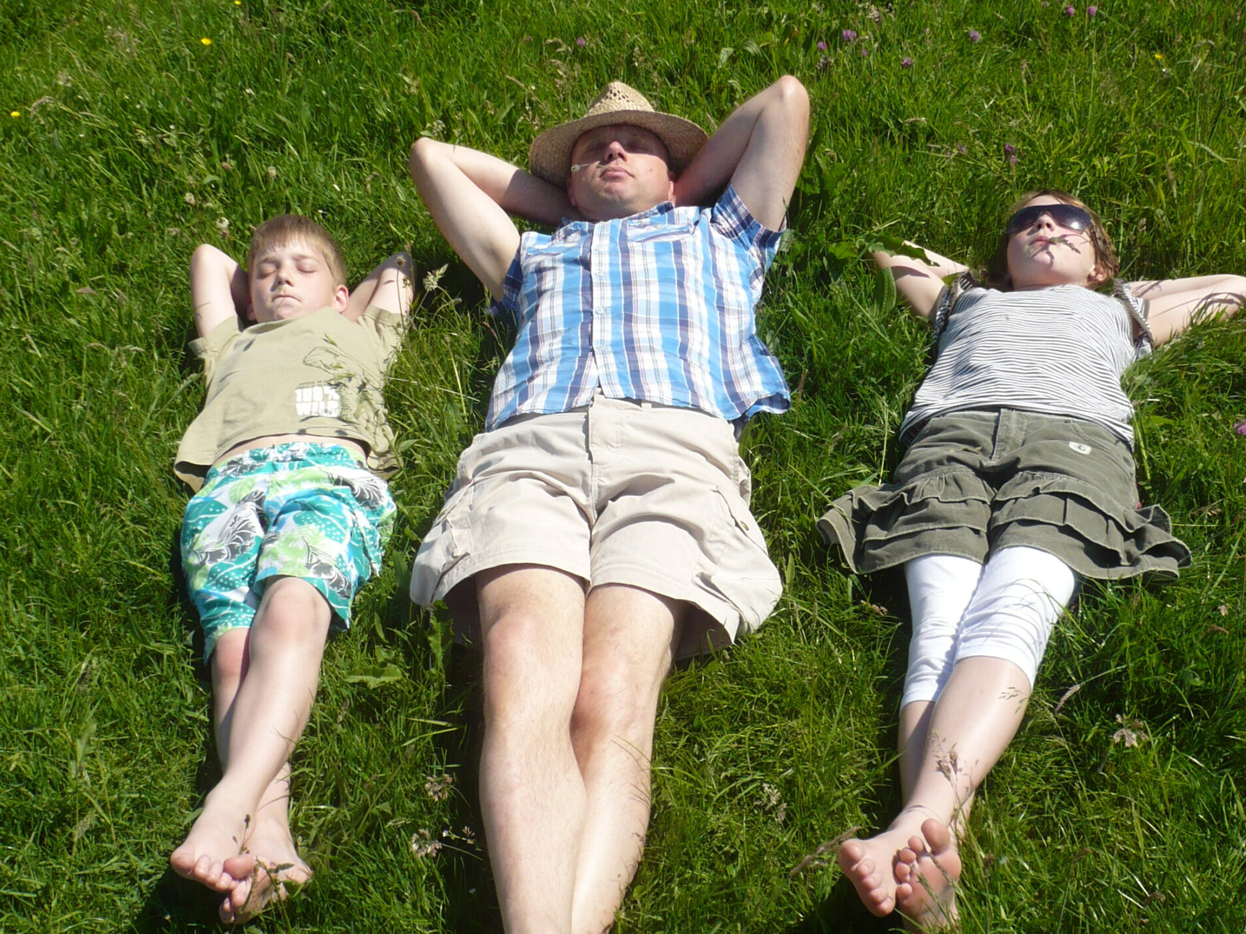 3 bezoekers liggen op het gras